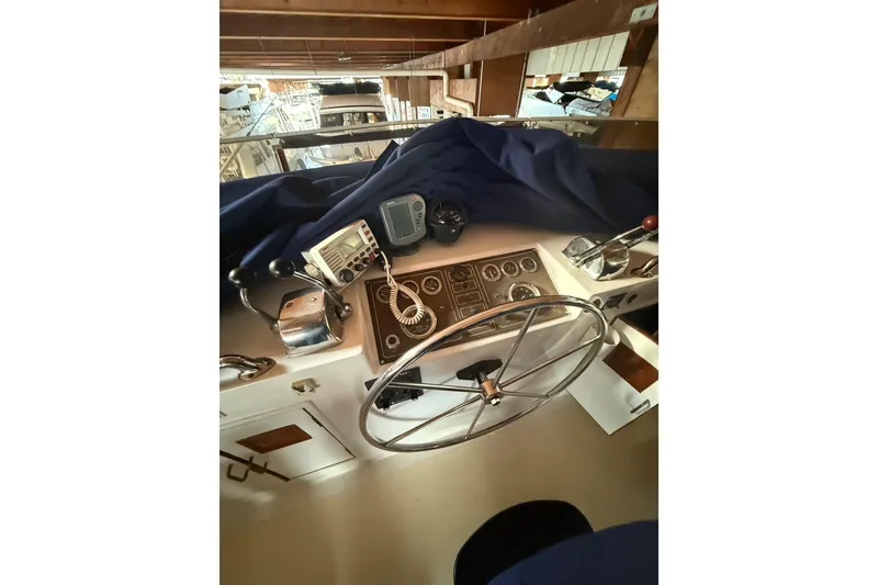 Slide: The Image of 1983 Ocean Alexander 43 Flush Aft Deck yacht helm with steering wheel and navigation instruments. - 15