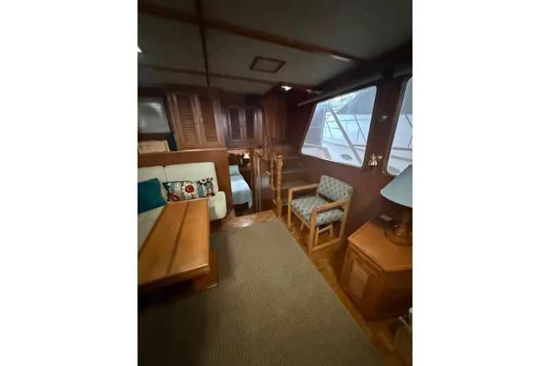 Slide: The Image of Interior of 1983 Ocean Alexander 43 Flush Aft Deck yacht, featuring cozy seating and wooden furnishings. - 5