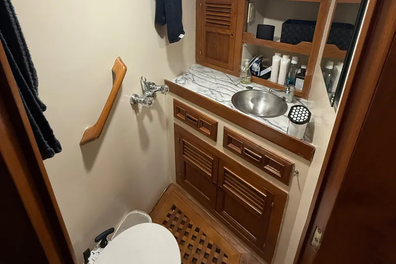 Slide: The Image of 1978 DeFever 39 yacht bathroom with wooden cabinets and marble countertop. - 8