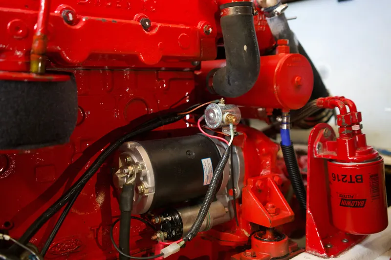 Slide: The Image of Engine components of a 1978 DeFever 39, featuring red mechanical parts and wiring. - 20