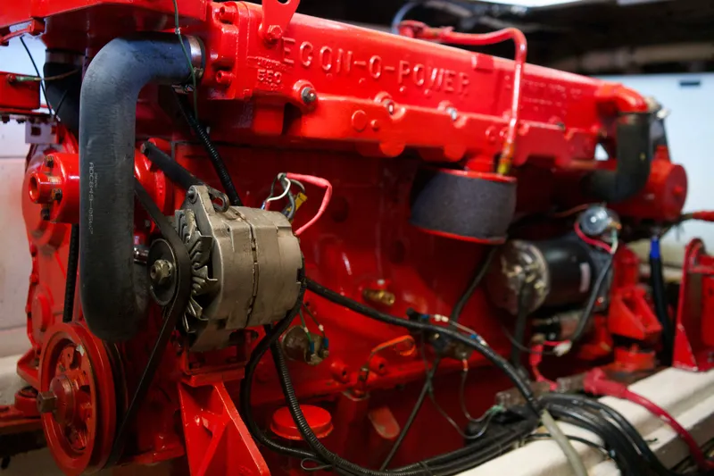Slide: The Image of Red engine of a 1978 DeFever 39 boat, showcasing mechanical components and wiring. - 16