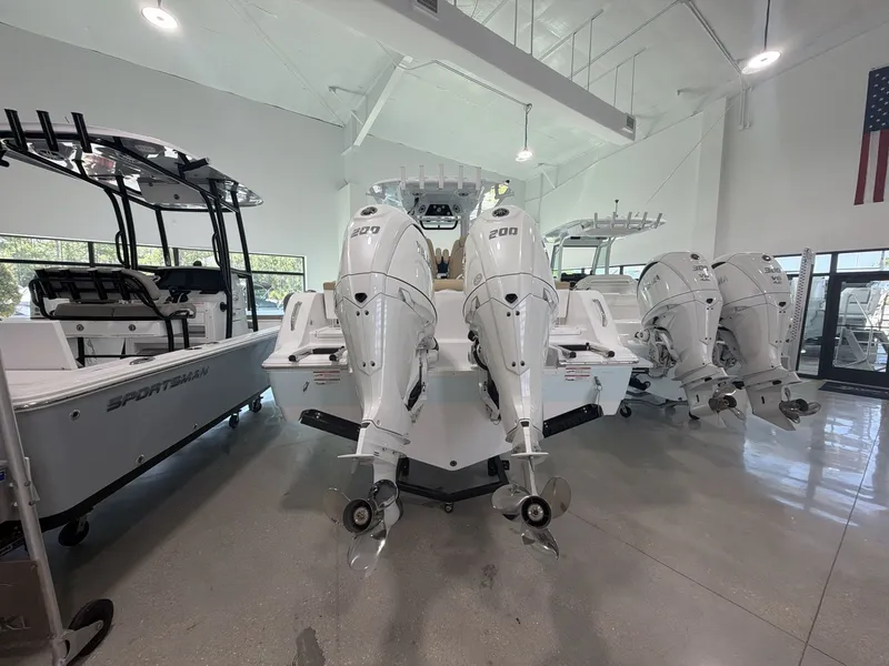 Slide: The Image of A 2027 Sportsman Heritage 261 Center Console boat with dual powerful outboard engines in a showroom. - 8