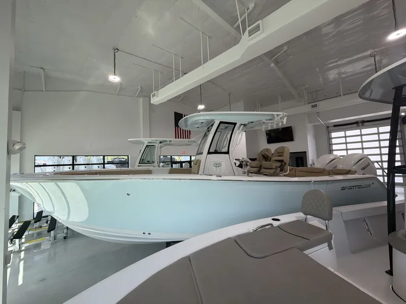 Slide: The Image of A 2027 Sportsman Heritage 261 Center Console boat is displayed in a modern showroom. - 2