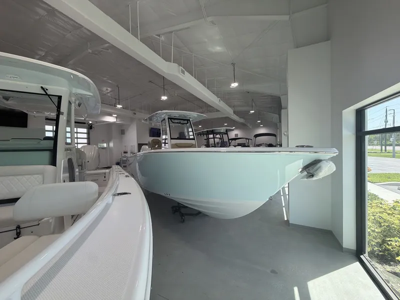 The Image of A 2027 Sportsman Heritage 261 Center Console boat is displayed in a modern showroom. - 1