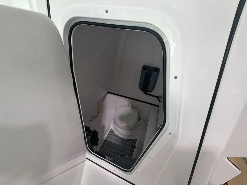 Slide: The Image of The image shows a compact boat toilet with a white interior and a small window. - 4