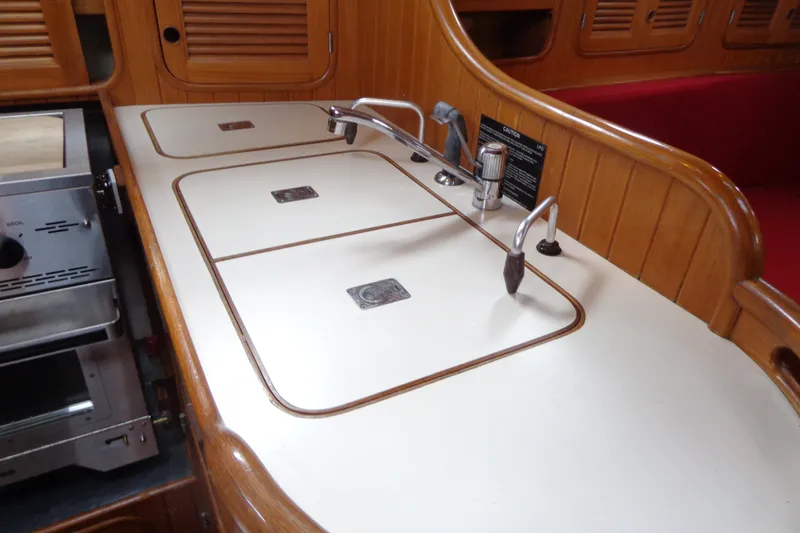 Slide: The Image of 1988 Ta Shing Tashiba Cutter yacht galley with wooden cabinetry and integrated sink. - 21