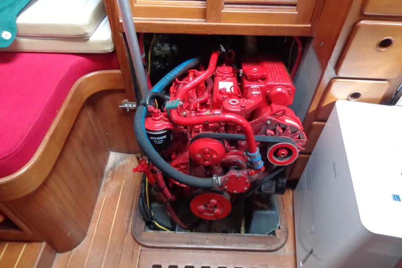Slide: The Image of Engine compartment of a 1988 Ta Shing Tashiba Cutter sailboat, featuring a red marine engine. - 38