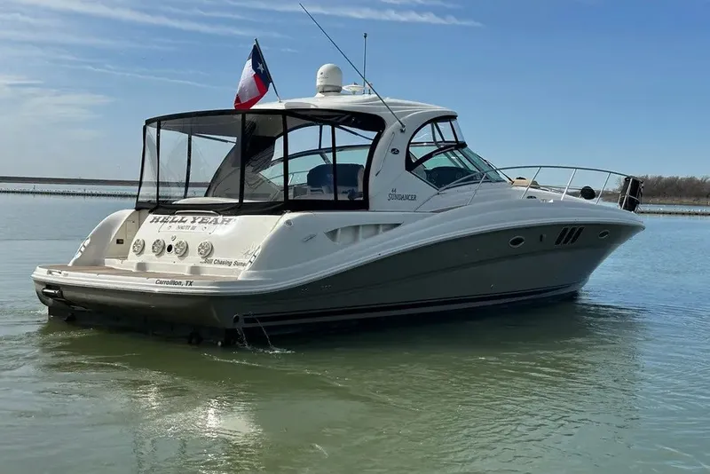 Slide: The Image of 2006 Sea Ray 44 Sundancer yacht on calm water, featuring sleek design and Texas flag. - 13