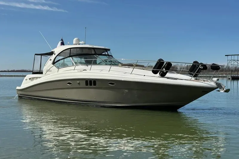 Slide: The Image of 2006 Sea Ray 44 Sundancer yacht on calm water under clear blue sky. - 17