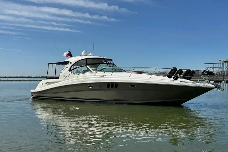 Slide: The Image of 2006 Sea Ray 44 Sundancer yacht on calm water under clear blue sky. - 16