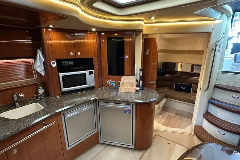 Slide: The Image of Luxurious 2006 Sea Ray 44 Sundancer yacht interior with modern kitchen and cozy seating area. - 23