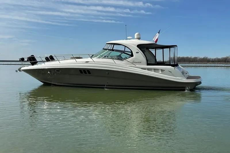 Slide: The Image of 2006 Sea Ray 44 Sundancer yacht cruising on calm water under a clear sky. - 2