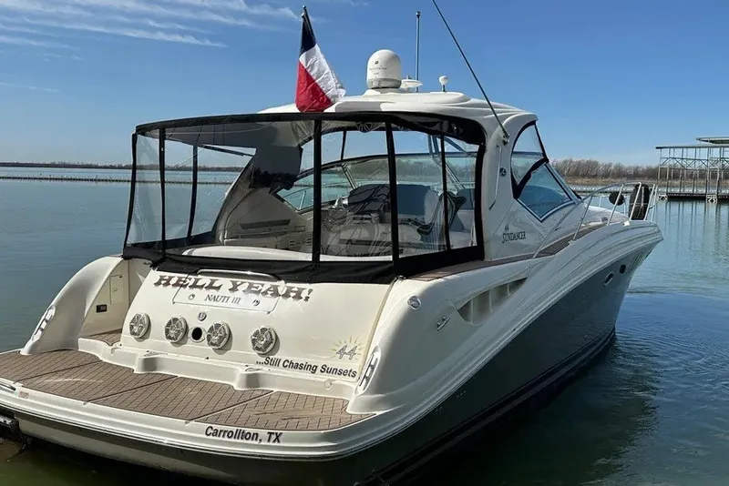 Slide: The Image of 2006 Sea Ray 44 Sundancer yacht docked on calm water, rear view with flag. - 12