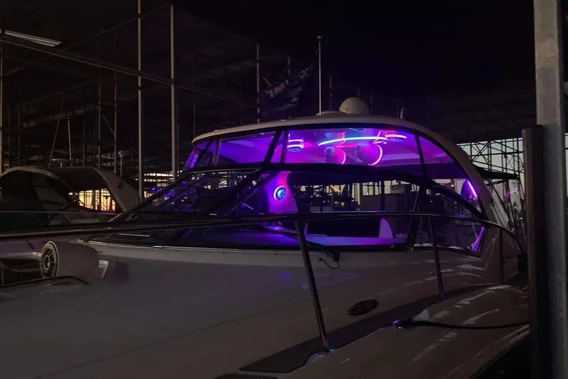 Slide: The Image of 2006 Sea Ray 44 Sundancer yacht with vibrant purple interior lighting at night. - 49
