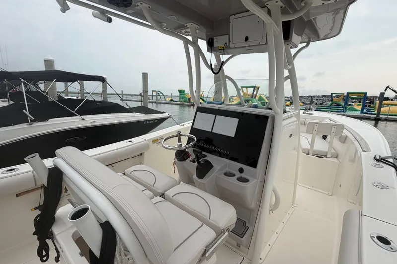Slide: The Image of 2021 Seaborn SX 239 boat interior with helm, docked at marina. - 20