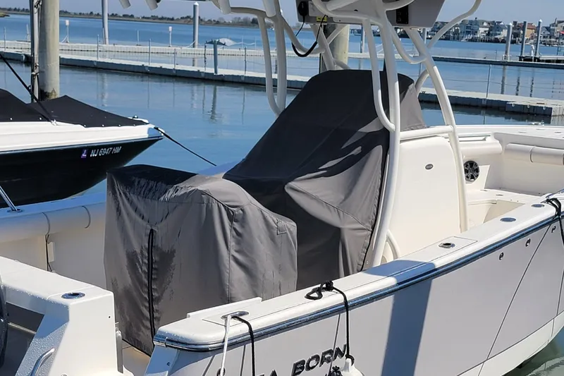 Slide: The Image of Covered Seaborn SX 239 boat docked, 2021 model, with calm water background. - 26