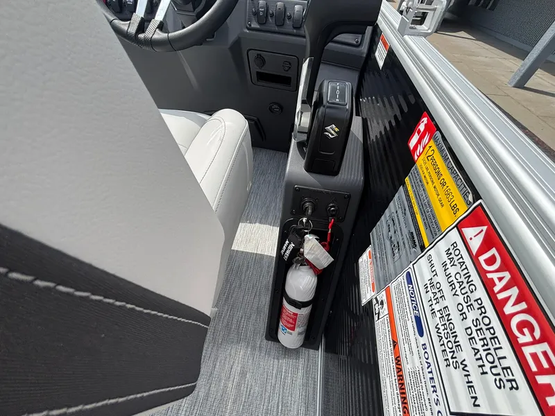 Slide: The Image of Close-up of a Bennington 22 S1SR SPS boat's helm area with fire extinguisher and warning labels. - 25