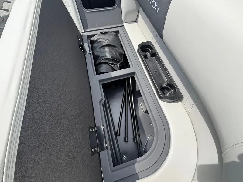 Slide: The Image of A storage compartment on a Bennington 22 S1SR SPS boat with a black bag and poles. - 28