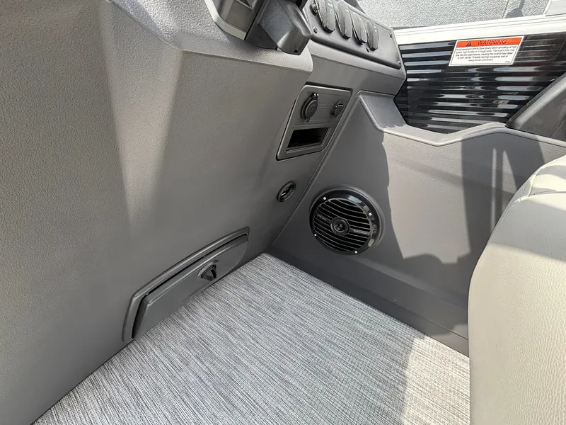 Slide: The Image of Close-up of a 2027 Bennington 22 S1SR SPS interior with gray carpeting and a speaker. - 23