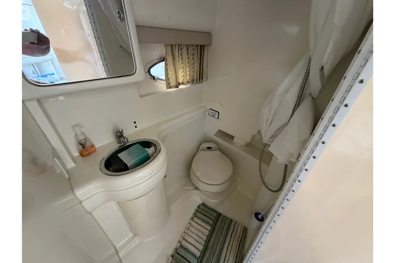 Slide: The Image of Compact bathroom in 2002 Formula 27 Performance Cruiser with sink, toilet, and shower. - 18