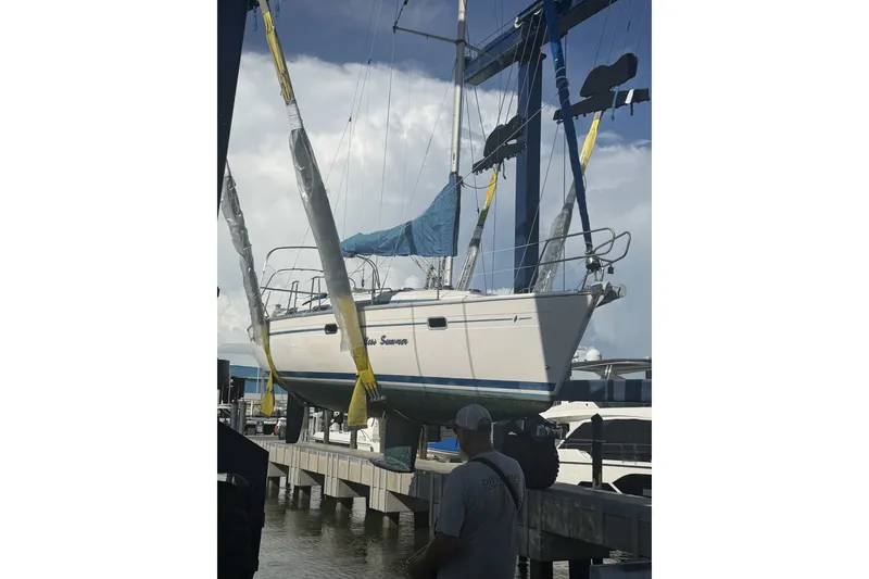 Slide: The Image of Bavaria Cruiser 37 sailboat from 2001 being lifted at a marina. - 53