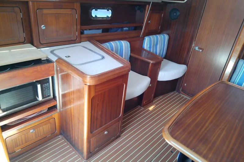 Slide: The Image of Interior of 2001 Bavaria Cruiser 37 yacht with wooden cabinetry and striped seating. - 22