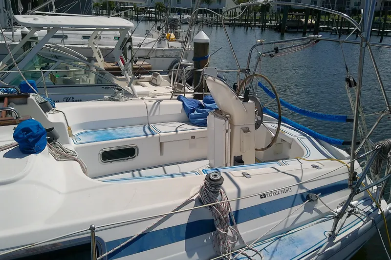Slide: The Image of 2001 Bavaria Cruiser 37 yacht docked at marina, featuring spacious deck and steering wheel. - 5