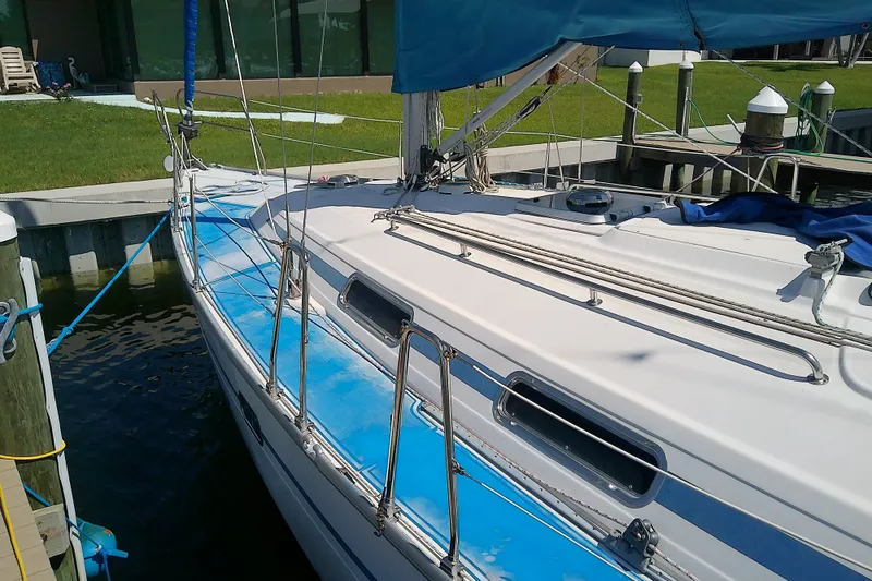 Slide: The Image of Sailboat Bavaria Cruiser 37, 2001 model, docked with blue deck and white hull. - 6