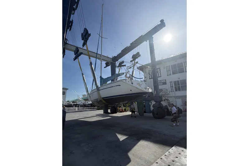 Slide: The Image of Bavaria Cruiser 37 sailboat from 2001 being lifted at a marina. - 52