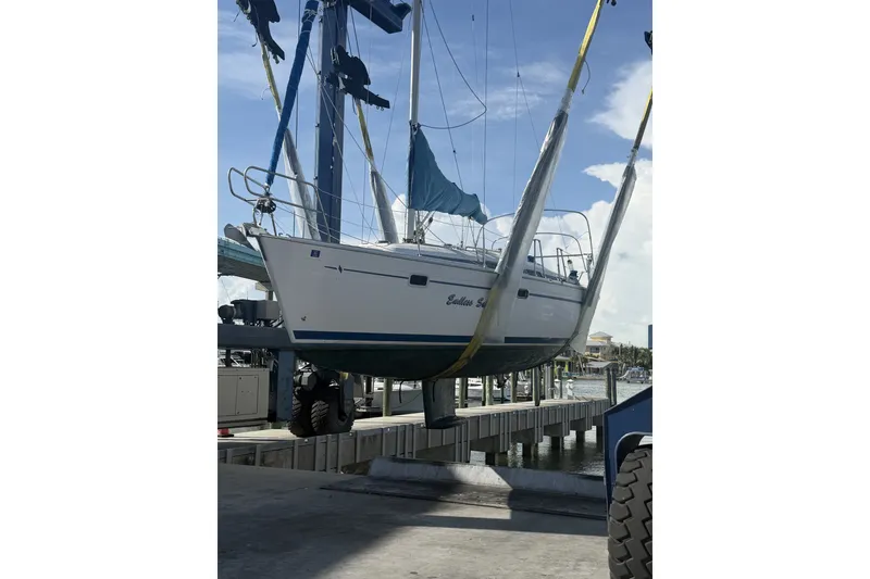 Slide: The Image of Bavaria Cruiser 37 sailboat from 2001 being lifted at a marina. - 54