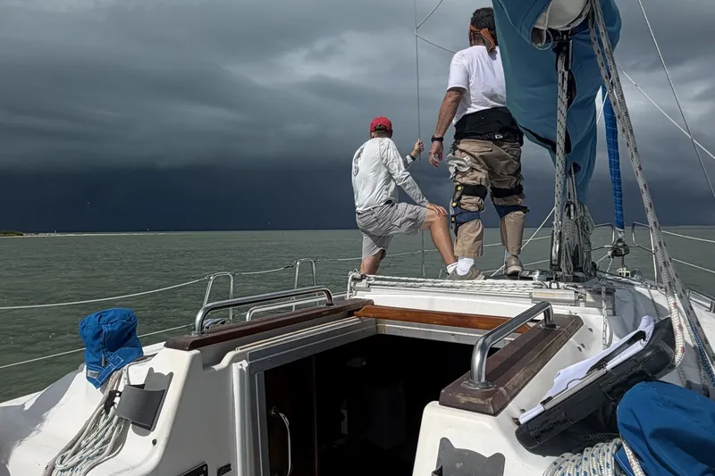 Slide: The Image of Two people on a Bavaria Cruiser 37 sailboat under stormy skies. - 55