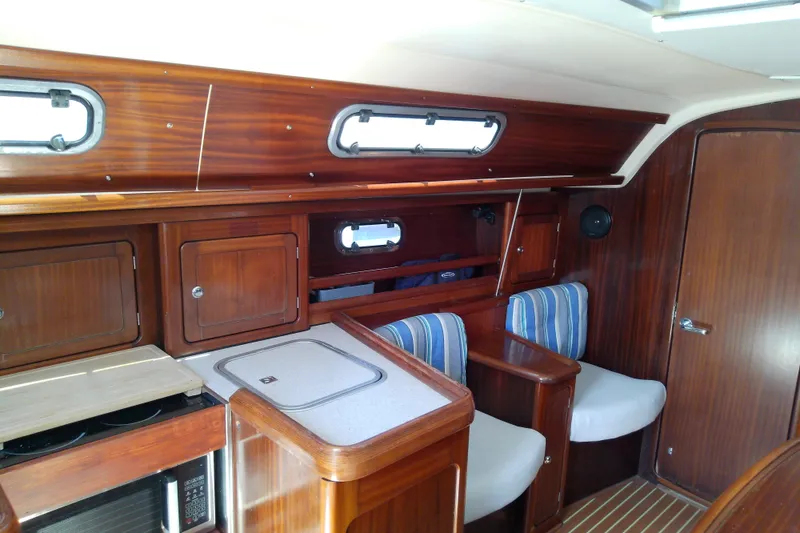 Slide: The Image of Interior of 2001 Bavaria Cruiser 37 yacht with wooden cabinetry and striped seating. - 23
