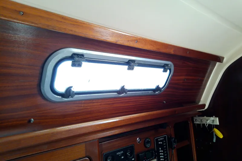 Slide: The Image of Interior view of a 2001 Bavaria Cruiser 37 yacht with a wooden finish and porthole. - 47