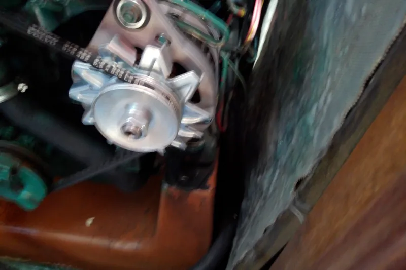 Slide: The Image of Engine component of a 2001 Bavaria Cruiser 37 sailboat, featuring a belt and pulley system. - 35