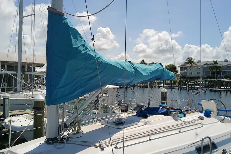 Slide: The Image of Sailboat Bavaria Cruiser 37, 2001 model, docked with blue sail cover, sunny marina backdrop. - 4