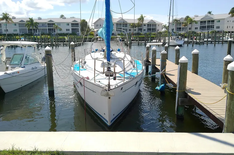Slide: The Image of Sailboat Bavaria Cruiser 37, 2001 model, docked at marina with waterfront condos. - 2