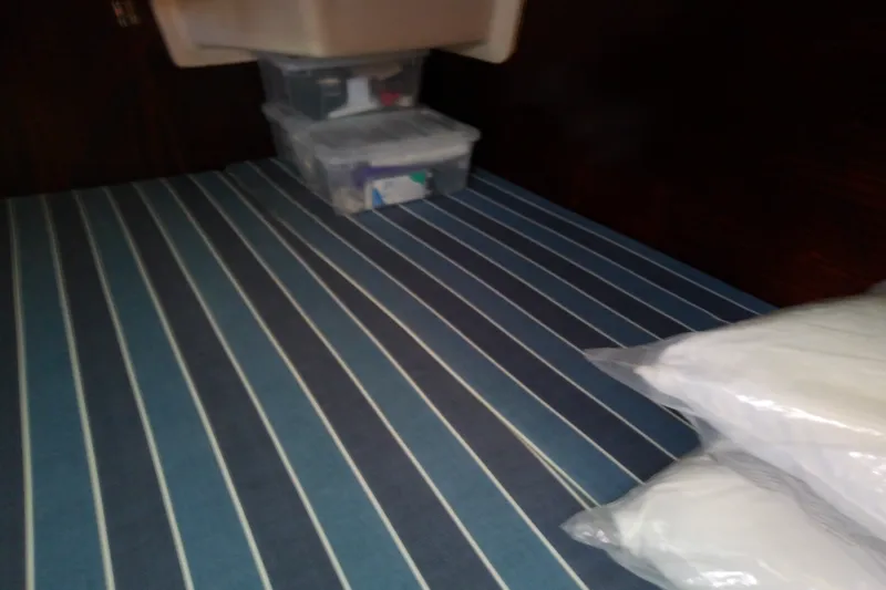 Slide: The Image of Interior cabin of 2001 Bavaria Cruiser 37 with striped bedding and storage boxes. - 39