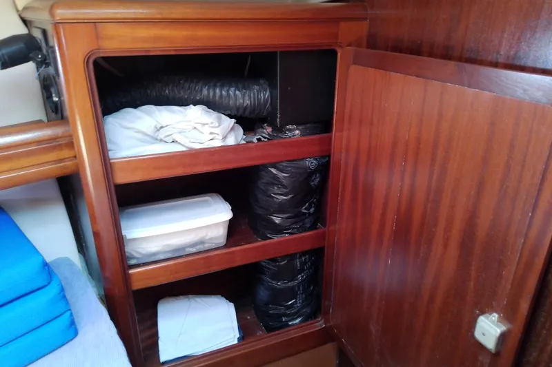Slide: The Image of Wooden cabinet storage inside a 2001 Bavaria Cruiser 37 yacht, featuring shelves with various items. - 43