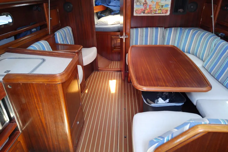 Slide: The Image of Interior of a 2001 Bavaria Cruiser 37 yacht with wooden furnishings and striped seating. - 21