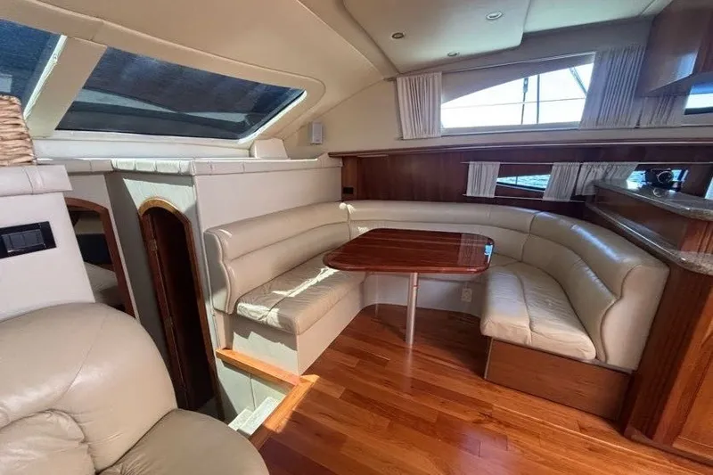 Slide: The Image of Luxurious 2004 Cruisers Yachts 455 Express Motoryacht interior with elegant seating and wooden table. - 23
