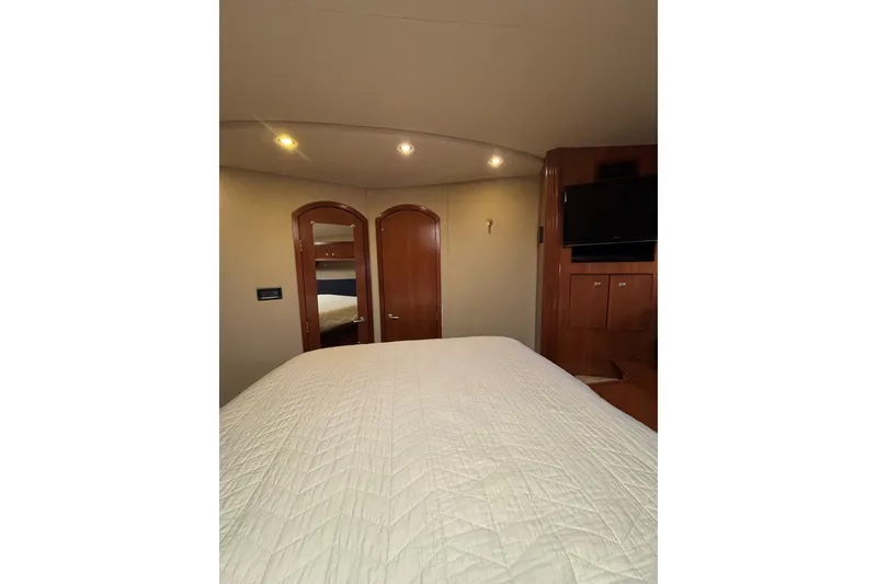 Slide: The Image of Luxurious bedroom interior of 2004 Cruisers Yachts 455 Express Motoryacht with wood accents and TV. - 34
