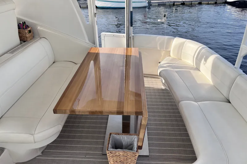 Slide: The Image of Luxurious seating area on 2004 Cruisers Yachts 455 Express Motoryacht with elegant wooden table. - 14