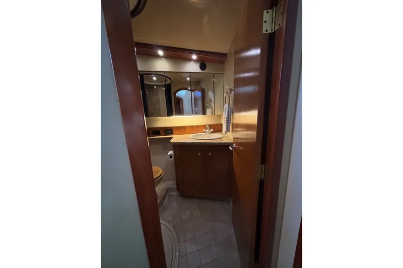 Slide: The Image of Luxurious bathroom in 2004 Cruisers Yachts 455 Express Motoryacht, featuring elegant wood cabinetry. - 35
