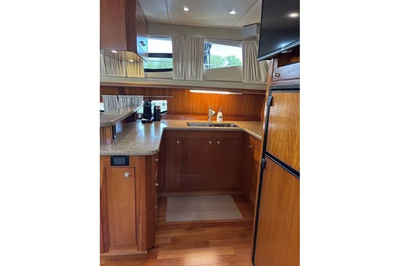Slide: The Image of Luxurious kitchen interior of 2004 Cruisers Yachts 455 Express Motoryacht with wood cabinetry. - 24