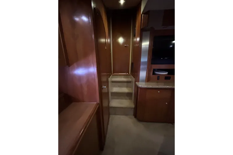 Slide: The Image of Interior of 2004 Cruisers Yachts 455 Express Motoryacht with wooden cabinetry and carpeted stairs. - 43