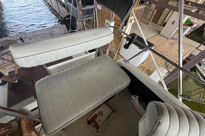 Slide: The Image of 1987 Carver 32 Aft Cabin Motor Yacht interior with white seating and dock view. - 18