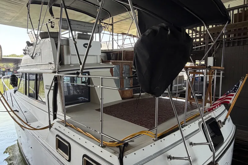 Slide: The Image of 1987 Carver 32 Aft Cabin Motor Yacht docked, featuring spacious deck and American flag. - 6