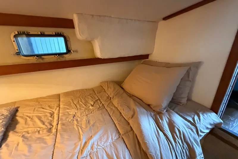 Slide: The Image of Cozy cabin interior of 1987 Carver 32 Aft Cabin Motor Yacht with bed and porthole window. - 43