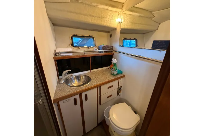Slide: The Image of 1987 Carver 32 Aft Cabin Motor Yacht bathroom with sink, toilet, and storage cabinets. - 31