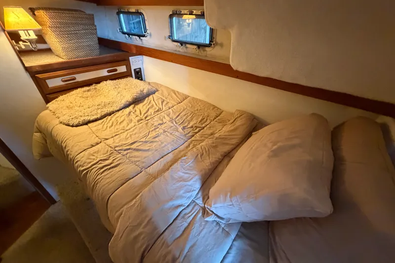 Slide: The Image of Cozy cabin interior of 1987 Carver 32 Aft Cabin Motor Yacht with bed and portholes. - 36